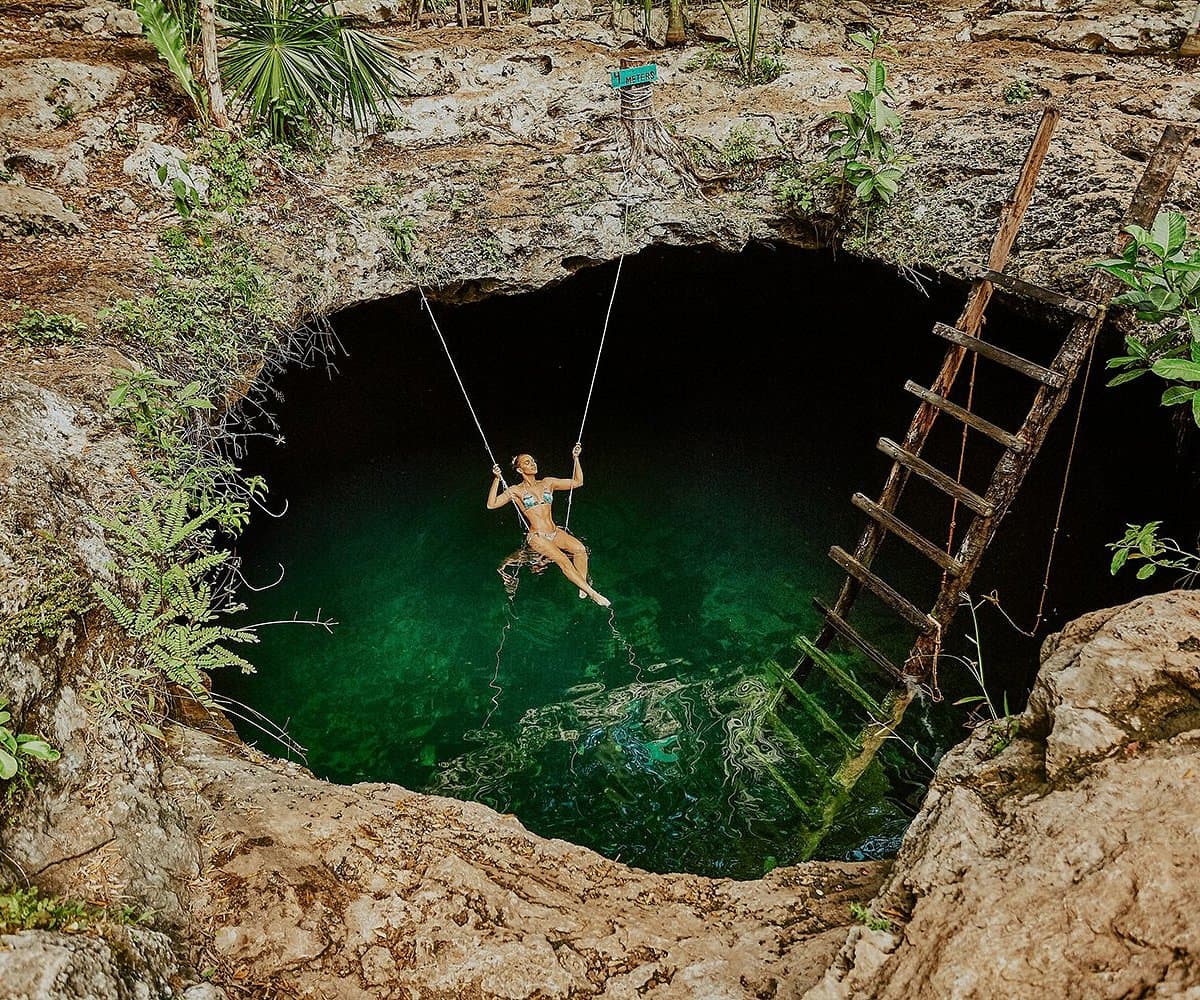 A traveler swinging at Cenote Calavera near Tulum